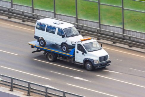 Carriage of a small minibus on the platform tow truck